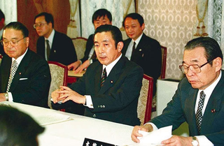 Prime Minister Hashimoto (center) holds an emergency meeting to discuss giant-monster containment strategies.